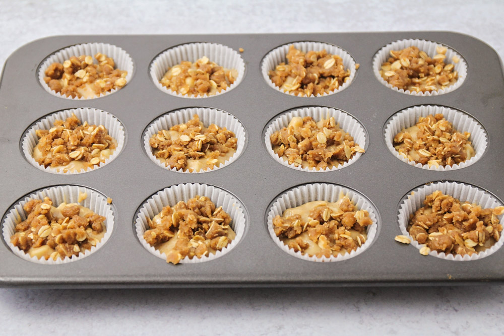 Apple muffins with oat topping in a muffin tin