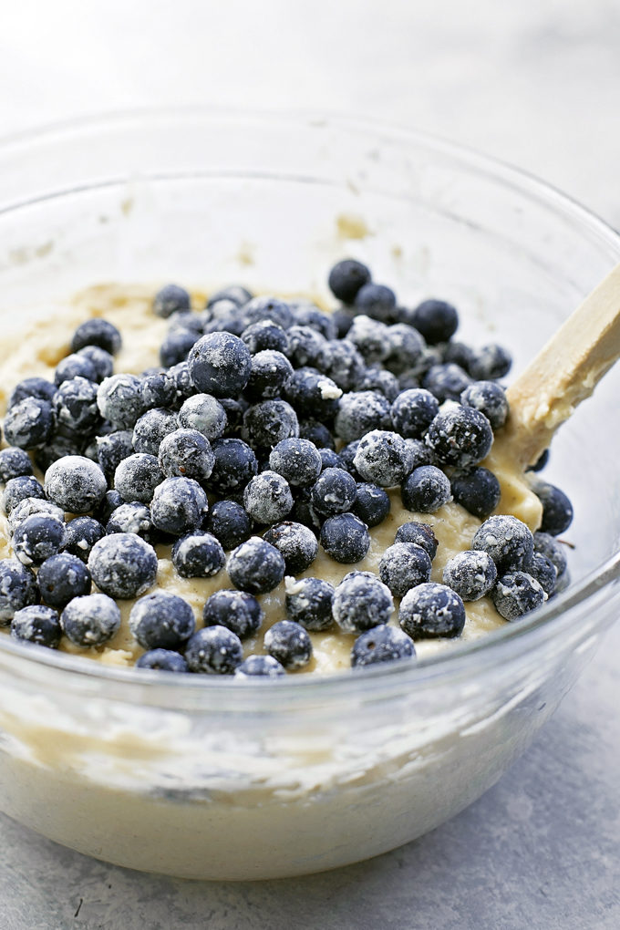 Mixing blueberries into batter for blueberry crumble muffin recipe
