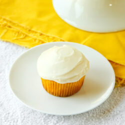 A white plate with crushed pineapple cupcakes.