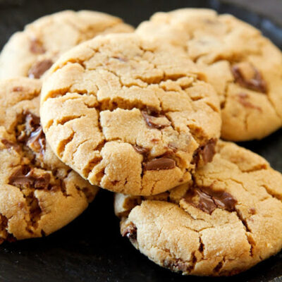A plate with peanut butter cookies and Reese's cups.