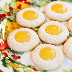 Lemon thumbprint cookies with lemon curd served on a plate.