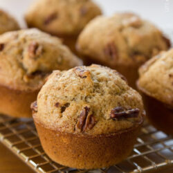 Cinnamon banana bread muffins cooling on a wire rack.