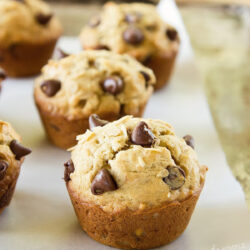 Freshly baked oat banana chocolate chip muffins on a tray lined with parchment paper.