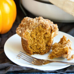 Streusel topped pumpkin muffins on a plate.