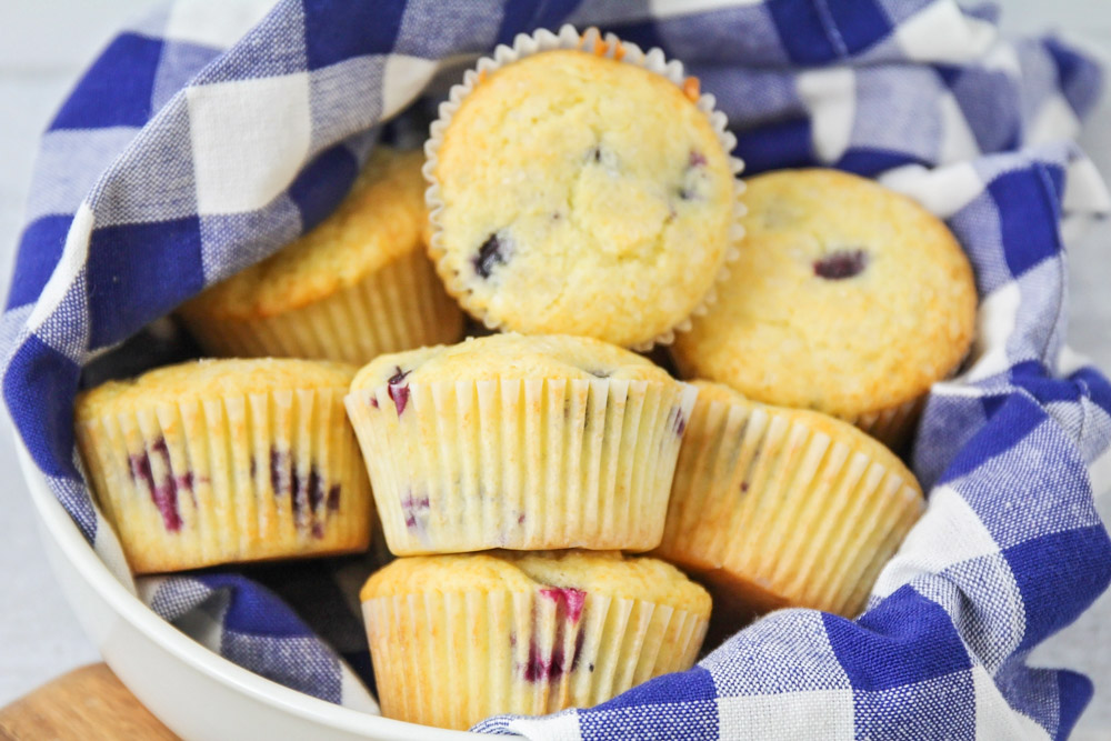 Blueberry muffins in bowl with dish towel