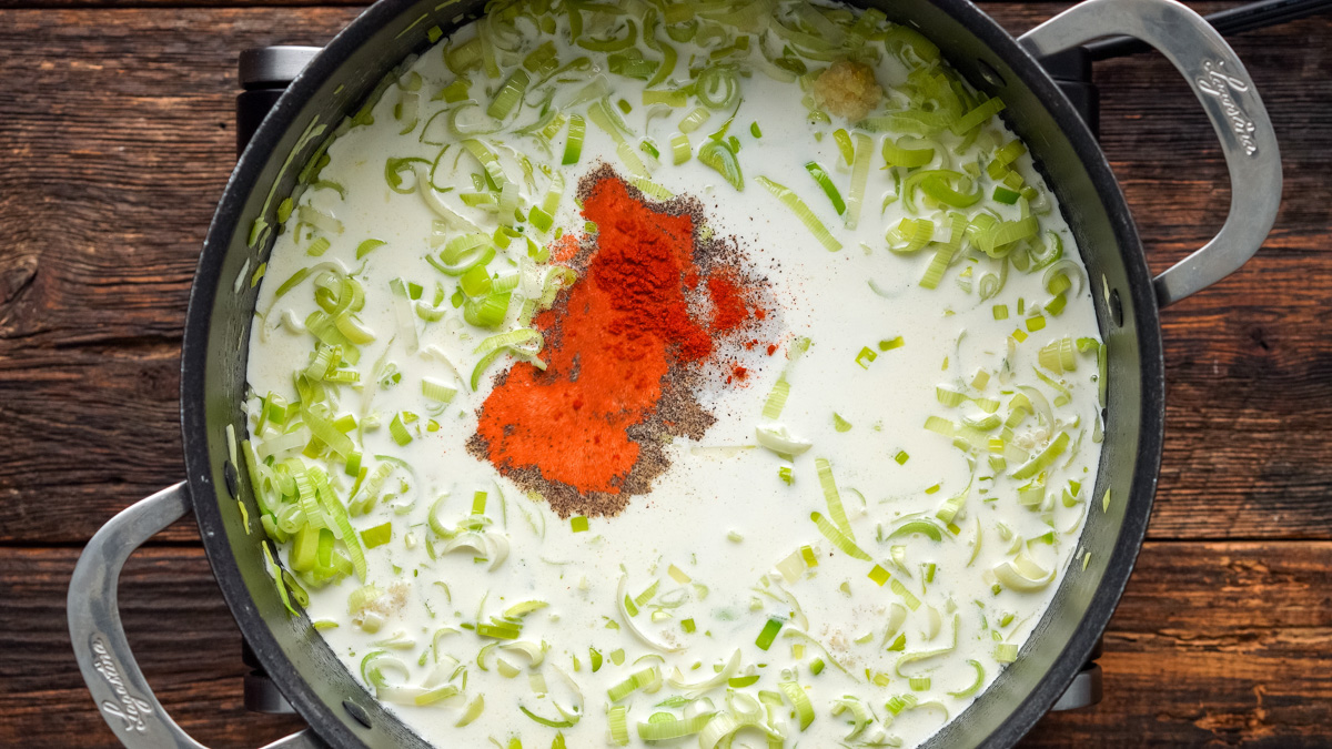 Milk, cream, and spices added into the skillet with the leeks and garlic.