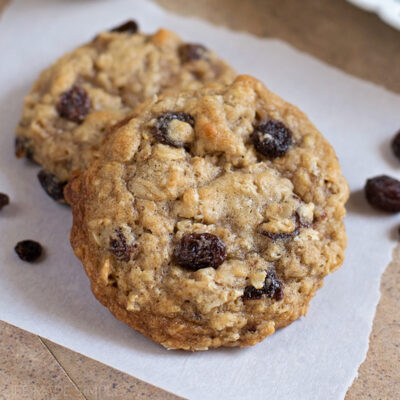 Chewy oatmeal raisin cookies on parchment paper.