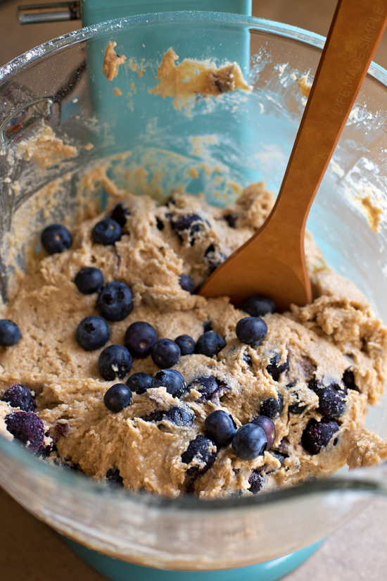Making blueberry muffins with whole wheat flour in a glass mixing bowl
