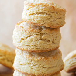 A stack of old-fashioned buttermilk biscuits on parchment paper.