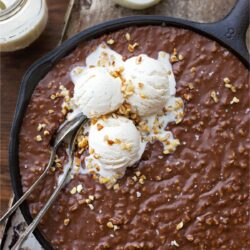 Texas sheet cake topped with chopped pecans in a cast iron skillet.