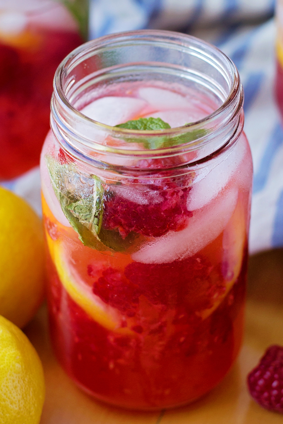 Raspberry Lemonade recipe in a jar with fresh berries, lemon slices, and peppermint