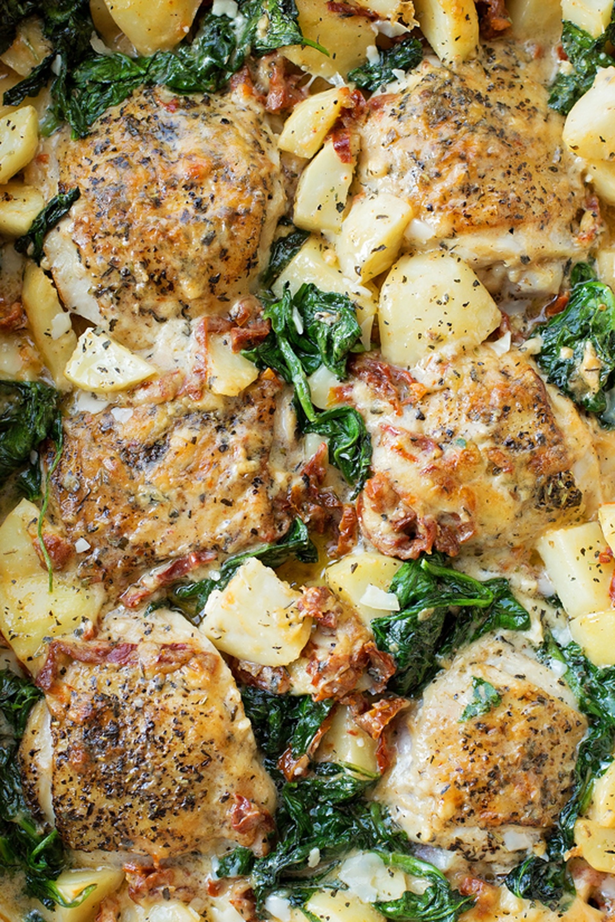 Golden-brown chicken thighs baked with creamy potatoes, wilted spinach, and sun-dried tomatoes in Tuscan sauce.