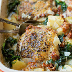 Creamy Tuscan Chicken and Potatoes served in a baking dish.