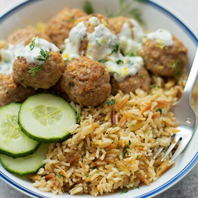 Greek pork meatballs with homemade tzatziki sauce served over rice.