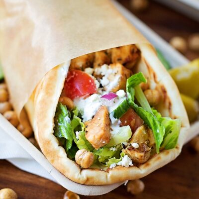 Greek grilled chicken pita wrapped in parchment paper.