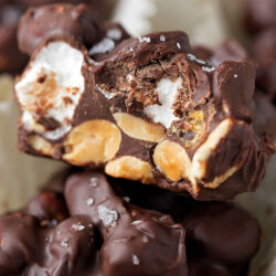 A close-up of a rocky road candy with a bite taken out.