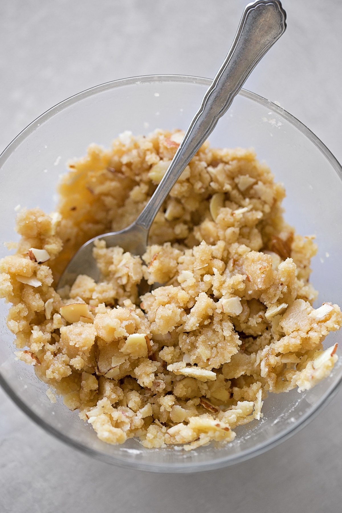 Prepared almond filling in a bowl with a spoon.