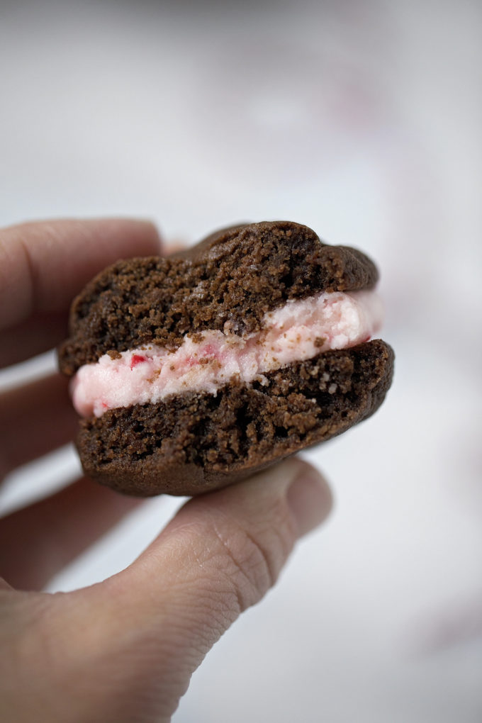 A close up of the inside of a chocolate mint sandwich cookie.