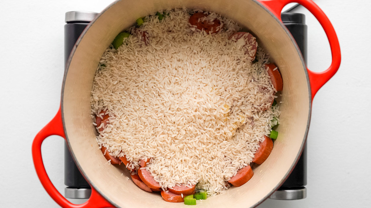 Rice added into a Dutch oven.