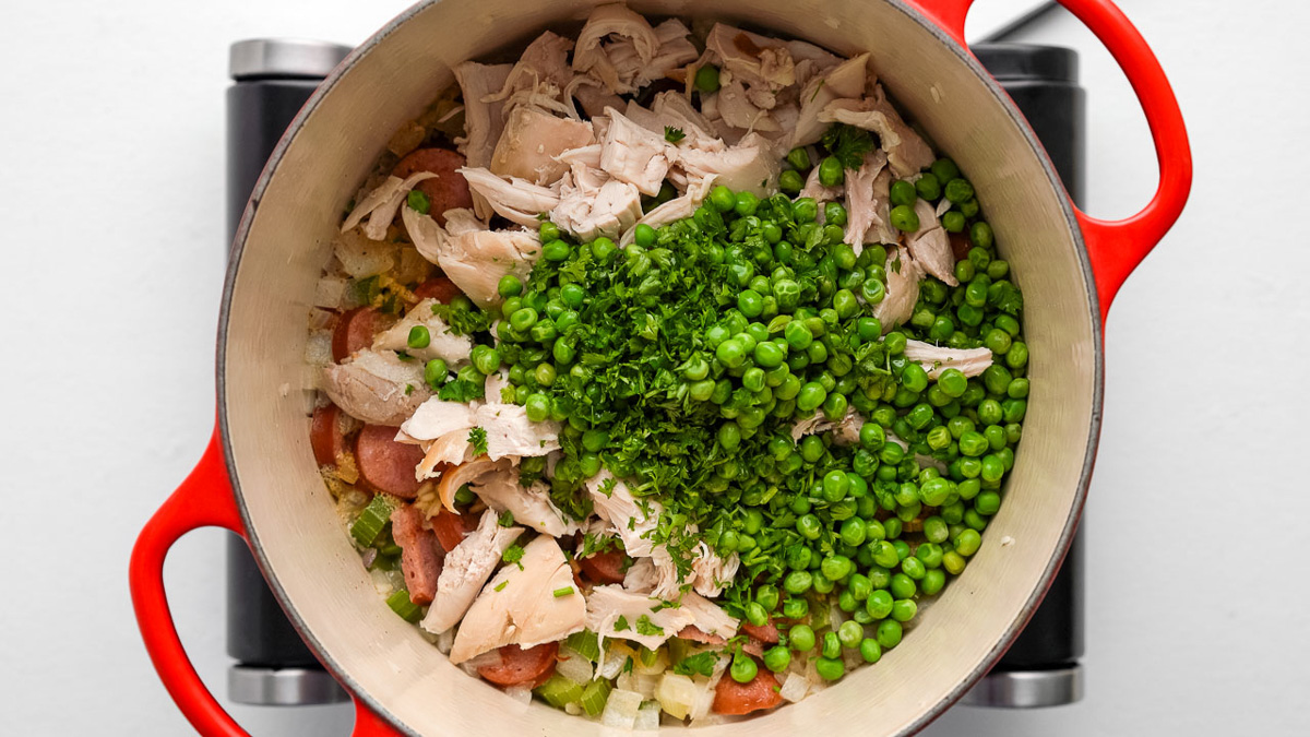 Chicken, peas, and parsley added into the Dutch oven.