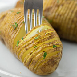 A plate with Hasselback potatoes garnished with parsley.