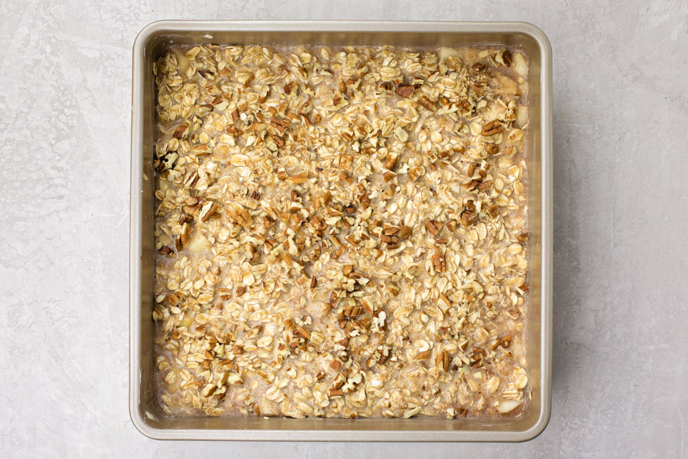 This Healthy Baked Apple Oatmeal is hearty and it's delicious! So easy to make, and perfect for a quick, healthy breakfast or snack throughout the week! Baked apple oatmeal in a pan
