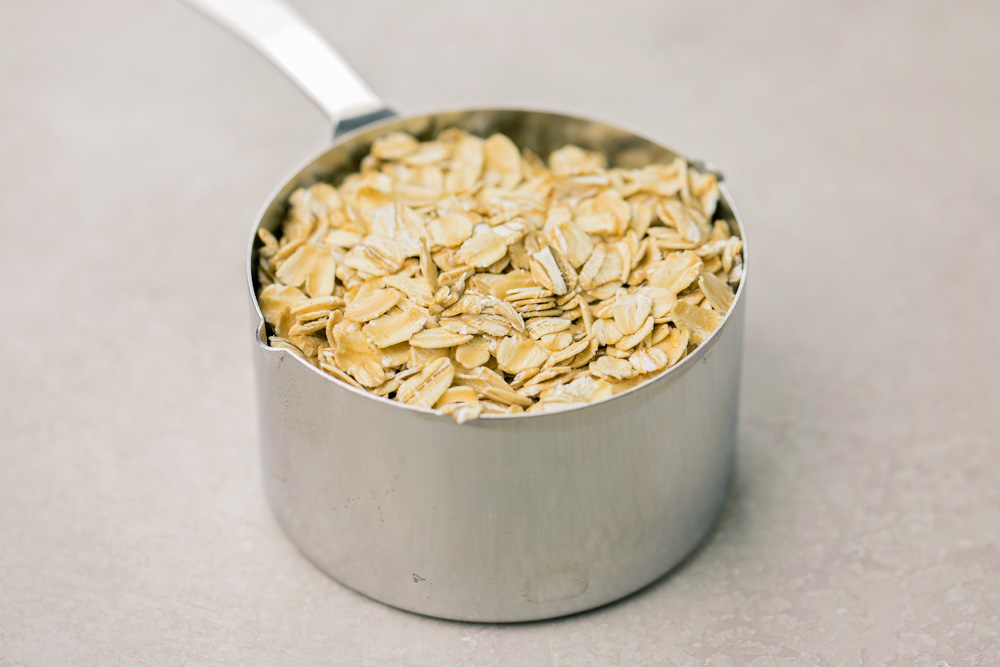 This Healthy Baked Apple Oatmeal is hearty and it's delicious! So easy to make, and perfect for a quick, healthy breakfast or snack throughout the week! Oats in a measuring cup