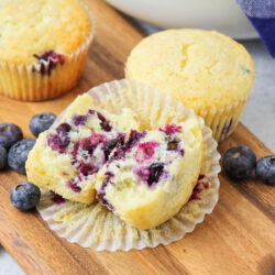 Blueberry muffins with buttermilk split in half on a wooden board.
