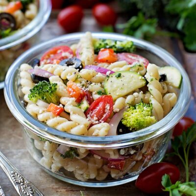 Pasta salad with veggies in a glass bowl.