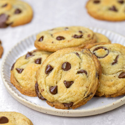A plate of golden brown eggless chocolate chip cookies.