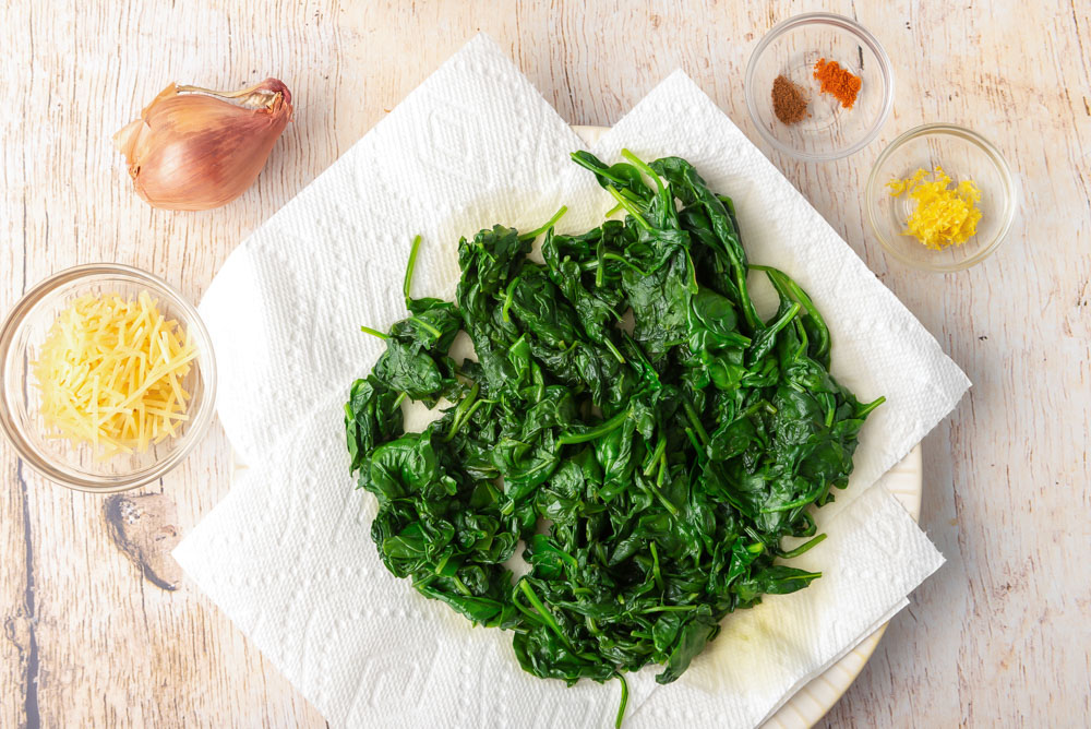 Wilted spinach and other ingredients for creamed spinach recipe