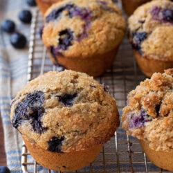 Blueberry muffins with whole wheat flour om a wire rack.
