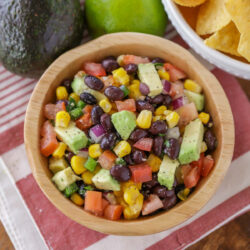 Avocado black bean and corn salsa in a wooden bowl.