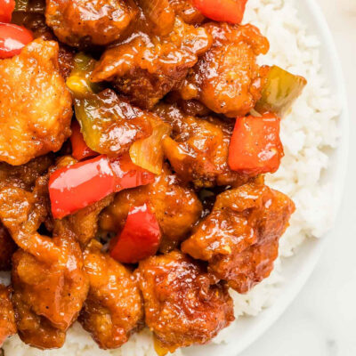 Crispy sweet and sour pork served on a bed of white rice.