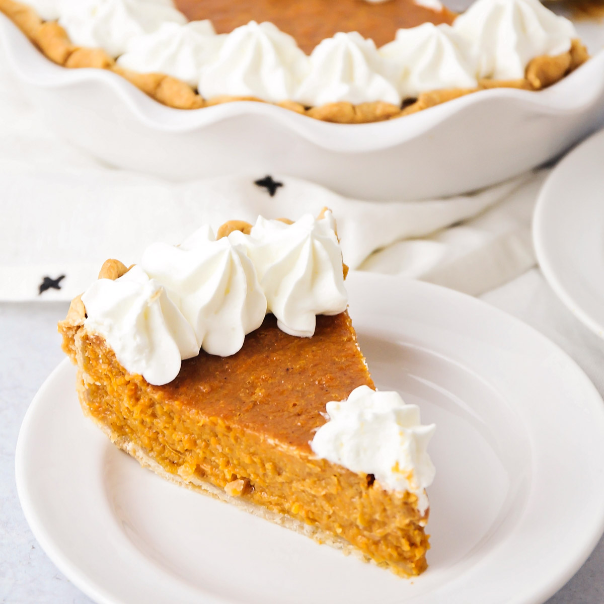 A slice of sweet potato pie on a white plate