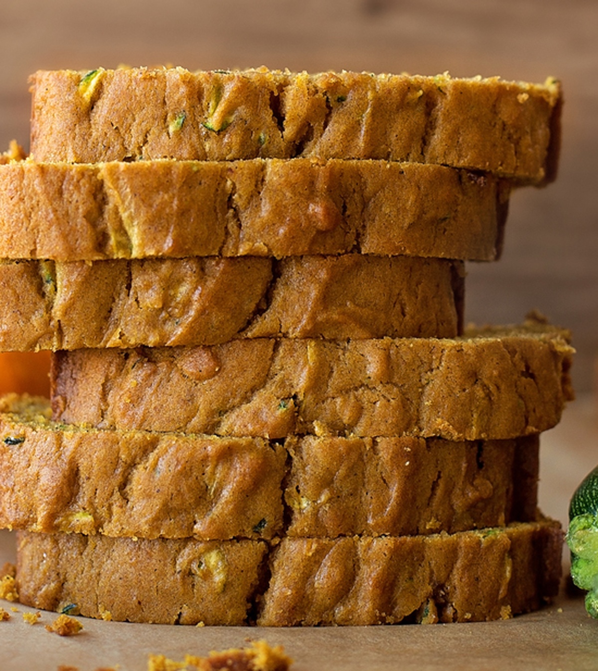 Pumpkin and spice adds a hint of fall to this moist and tender pumpkin zucchini bread. It's easy to make and even easier to customize! Close-up of a sliced loaf of pumpkin zucchini bread.
