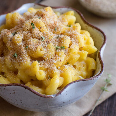 A bowl of butternut squash mac n cheese served on a table.