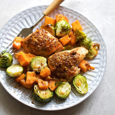 Maple Dijon chicken and vegetables on a white plate.