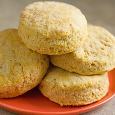A stack of freshly baked sweet potato buttermilk biscuits on a plate.