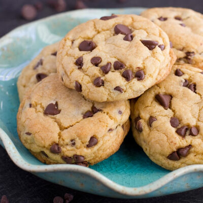 A stack of soft batch chocolate chip cookies in a bowl.