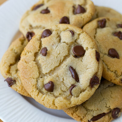 Perfect chocolate chip cookies stacked on a plate.