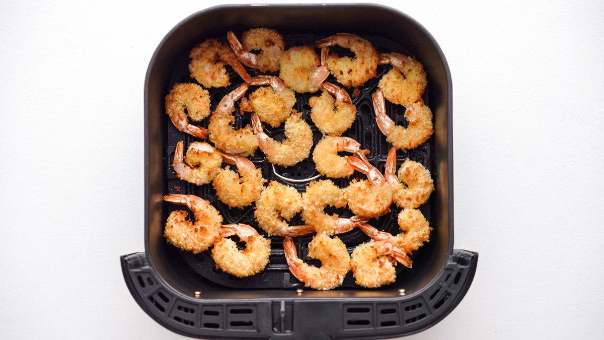Crispy shrimp cooked and sitting in an air fryer