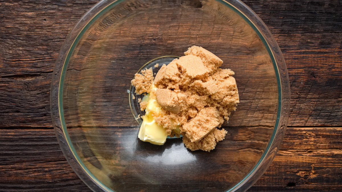 Butter and brown sugar in a glass bowl.