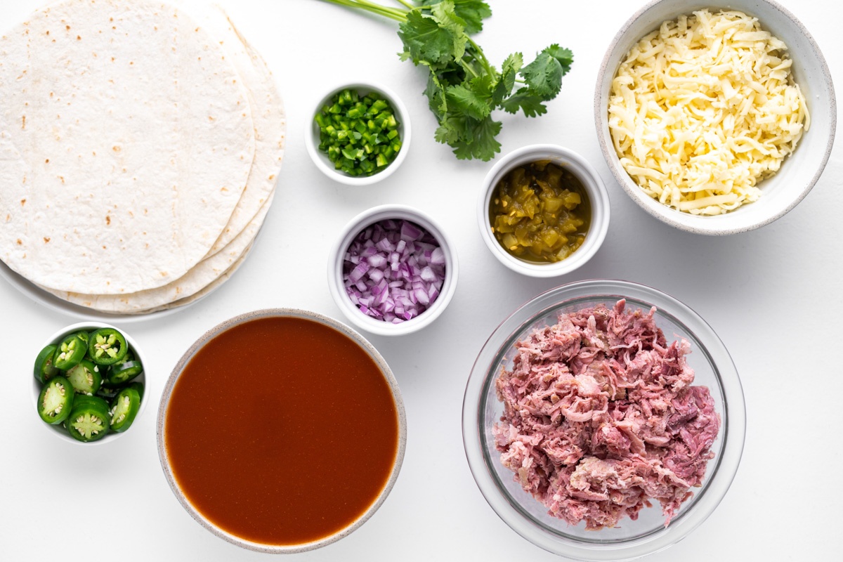 Ingredients gathered on a table for Mexican Pulled Pork Enchiladas recipe.