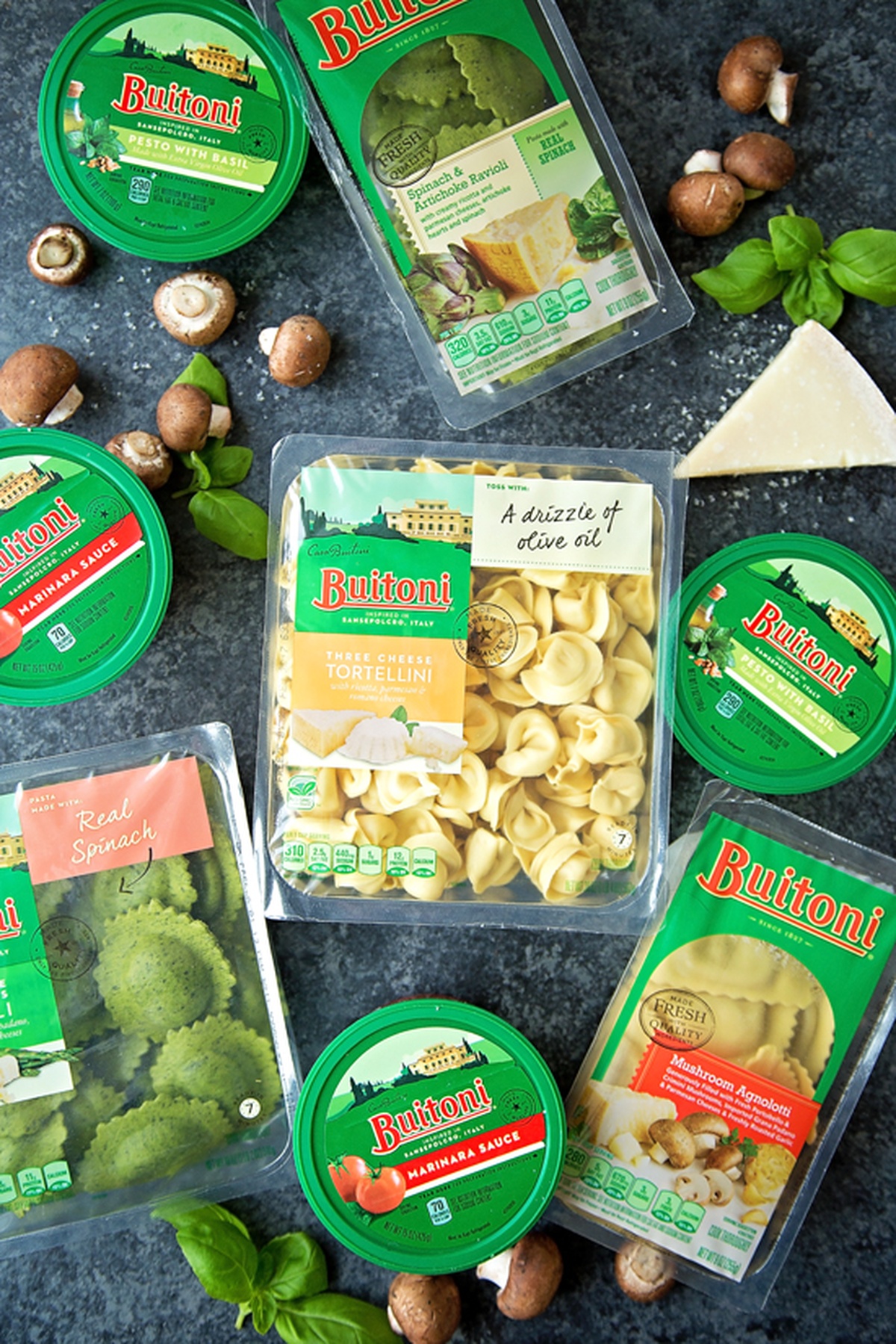 Buitoni pasta and sauce products displayed with fresh mushrooms and basil.