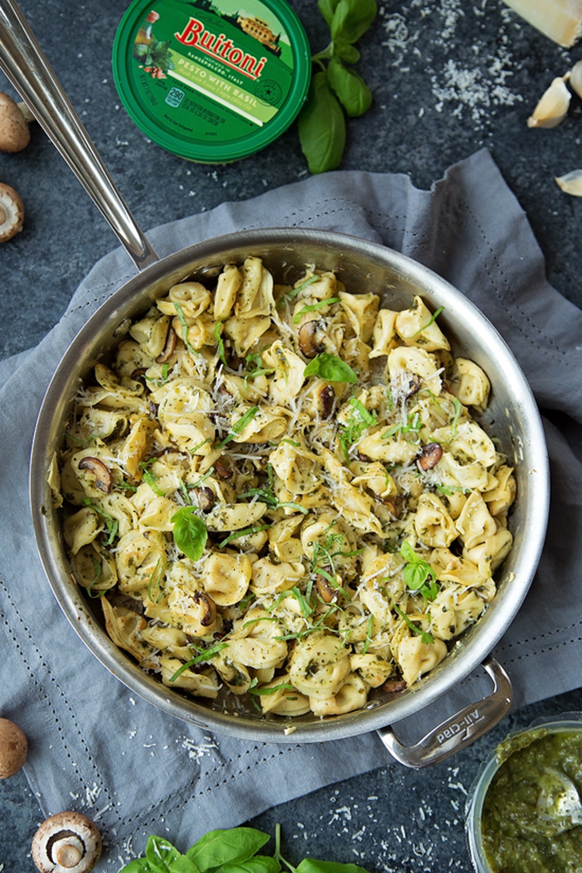 A skillet of tortellini and pesto sauce.