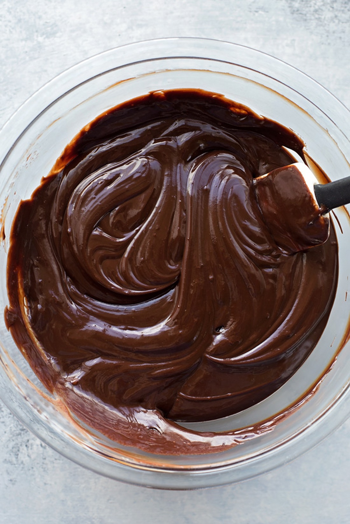 Bowl of rich chocolate cream being stirred.
