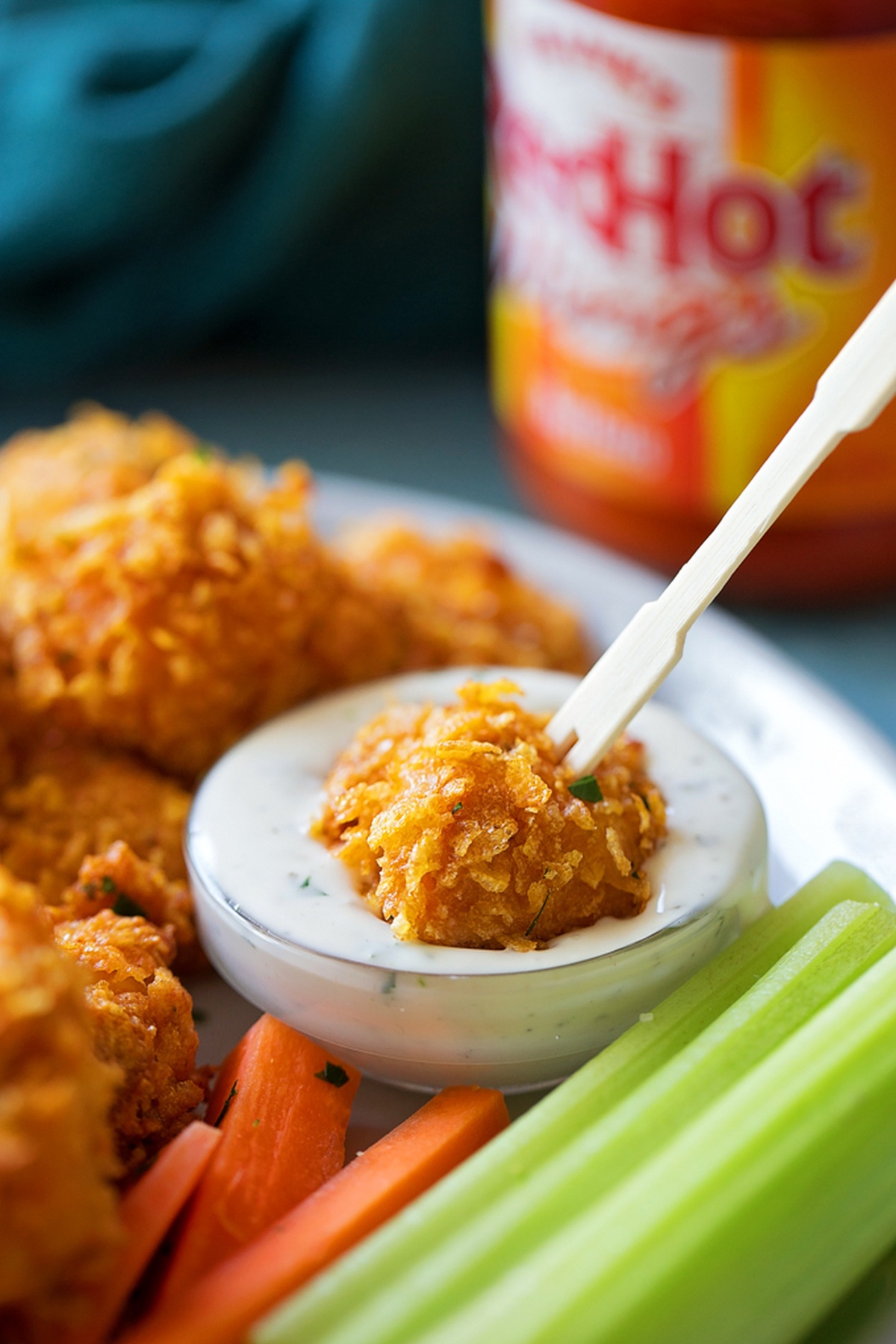 Close-up of a Buffalo chicken nugget dipped in ranch sauce.