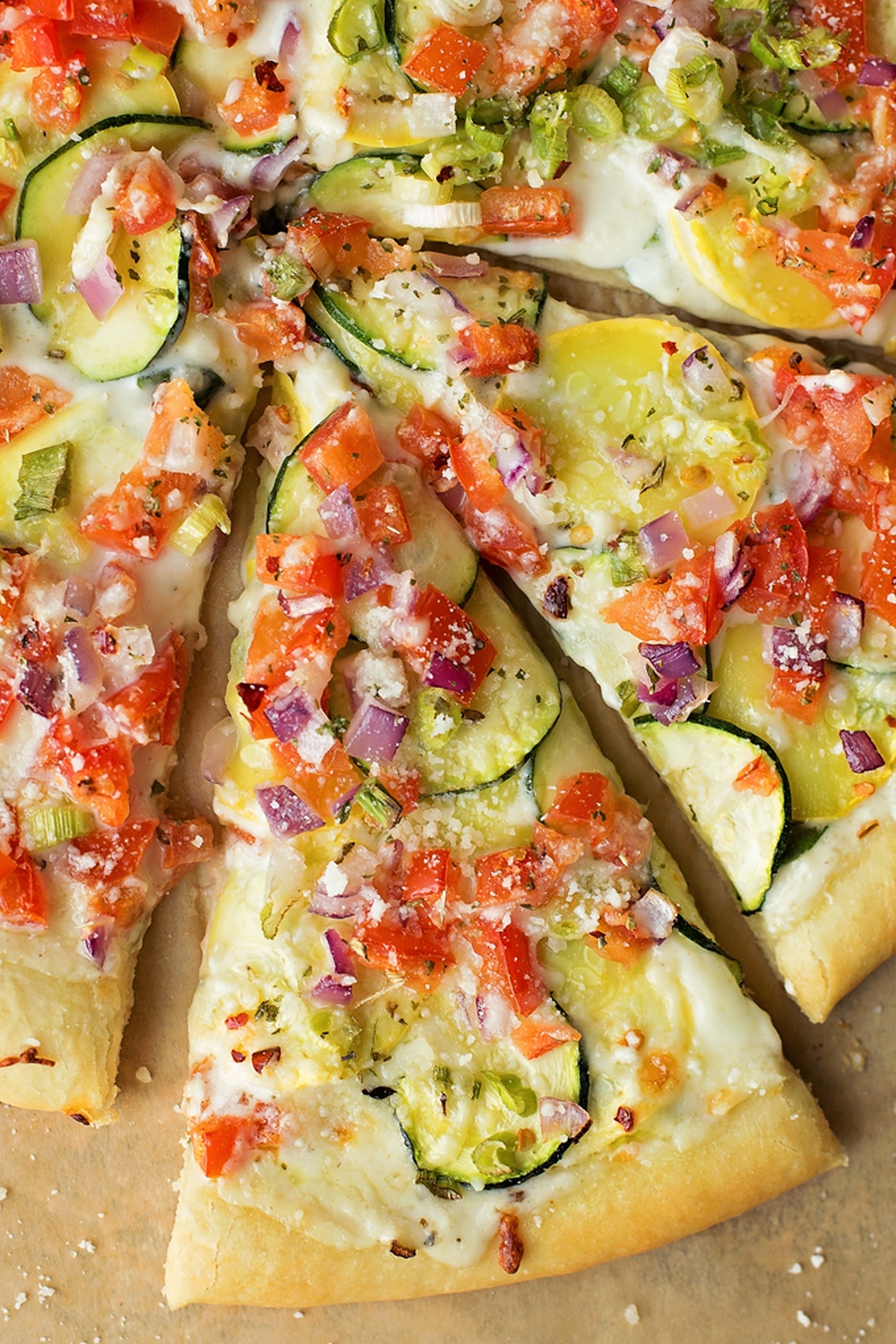 Close-up of veggie pizza with various toppings and melted cheese.