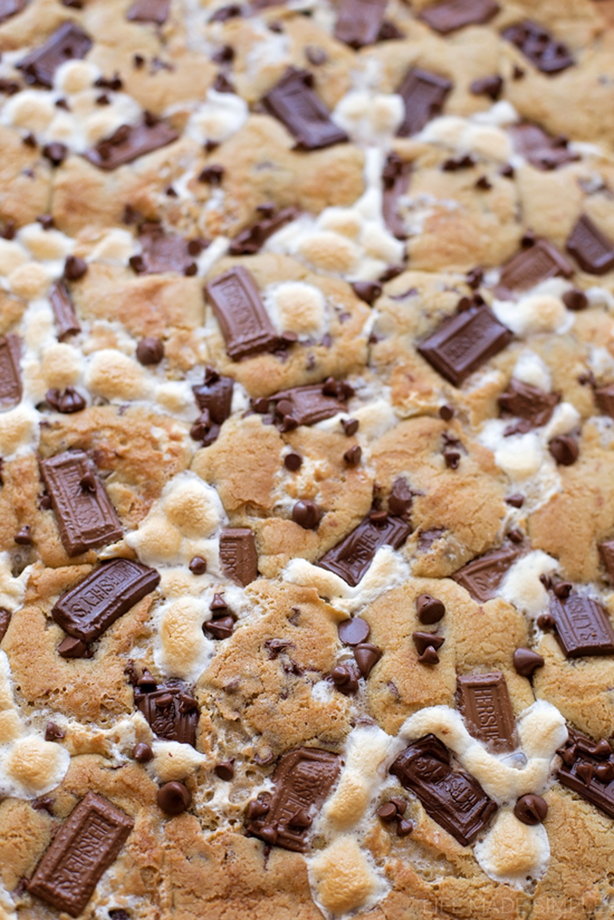 Baked graham cracker s'mores with melted chocolate pieces and marshmallows.